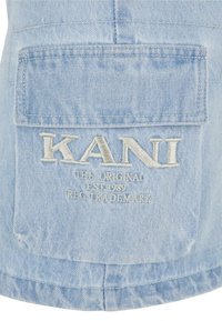 Hellblauer Denim-Weste mit einer großen Rückentasche. Gestickter Text "KANI" mit zusätzlichem Text darunter in Weiß. Weicher Stoff und lässiges Design.