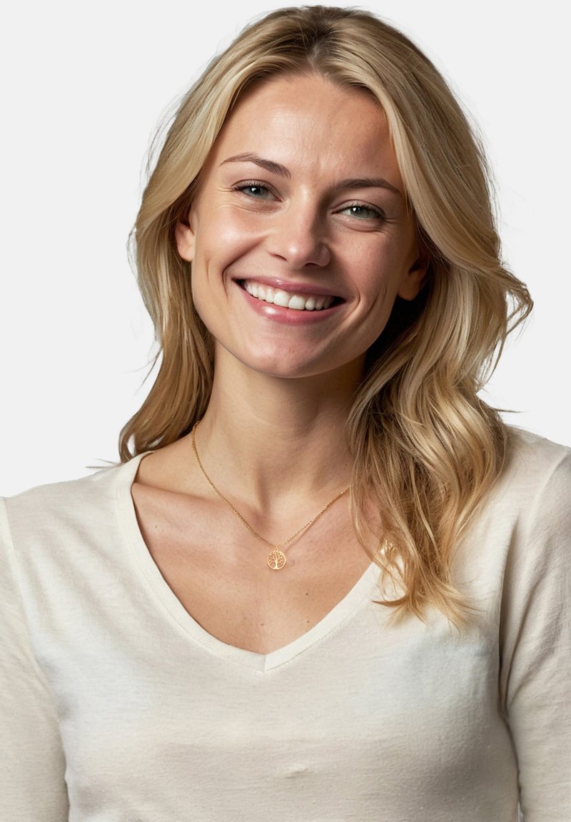 Goldene Halskette mit einem Baum-Anhänger, getragen von einer Person mit welligem blonden Haar, in einem hellen, v-ausschnitt, langärmeligen Hemd. Klarer Hintergrund.