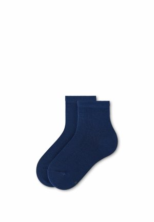 Paar schlichte marineblaue Knöchelsocken flach auf weißem Hintergrund gelegt.