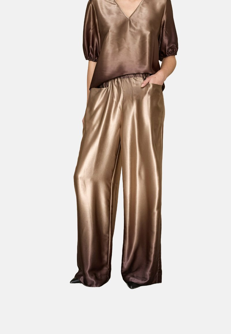 Silk bluse med korte ærmer og V-hals i brune nuancer, parret med matchende satin brede bukser med en glat, skinnende tekstur.
