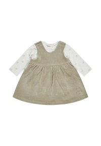 Beige Wellen-Rockkleid aus Cord, mit einem gerafften Rock und besticktem Katzenkopf, über einem weißen Langarm-Top mit Blumenmuster getragen.