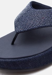 Σαγιονάρα πλατφόρμας σε ναυτικό μπλε με μαλακή σόλα και επάνω λουρί καλυμμένο με μικρά λαμπερά χάντρες.