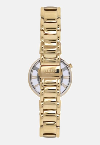 Gold metal watch with a polished link bracelet, transparent case, and round face displaying black hour markers and logo.