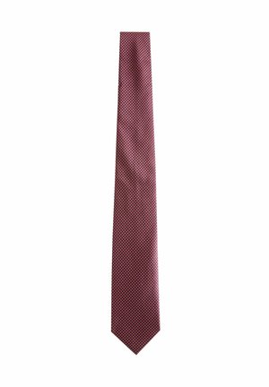 Red tie featuring a geometric pattern with small white and blue dots, made of smooth fabric with a pointed end and a slim design.