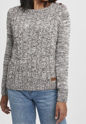 Sweter dzianinowy w odcieniach szarości i kremu z teksturowanym wzorem, okrągłym dekoltem, długimi rękawami i małą brązową metką logo na dolnym hemie.