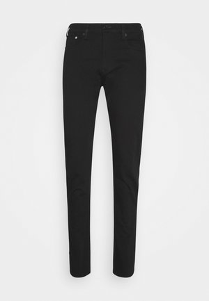 Slim fit mustat farkut, joissa on etu- ja takataskut, vyölenkit ja napillinen vyötärön suljenta, valkoisella taustalla esillä.