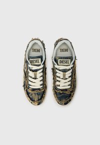 Denim sneakers med slitte kanter, blå og brun fargekombinasjon, hvite snører og merkede innersåler. Teksturert stoff og klassisk design.