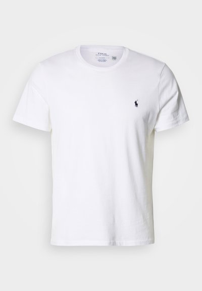 Camiseta branca de algodão com mangas curtas, apresentando decote redondo e pequeno logótipo azul-marinho no lado esquerdo do peito. Textura lisa, corte padrão.