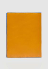 Oranje leren paspoorthoes met blauwe stiksels en contrasterende randen, met een gladde textuur en een minimalistisch ontwerp.