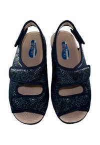 Sandalias azul marino con una parte superior texturizada, que cuentan con dos correas de Velcro ajustables y aberturas recortadas, sobre una plantilla acolchada beige.