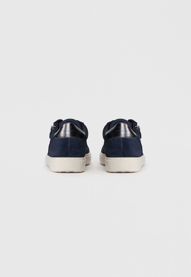 Navyblaue Wildledersneaker mit schwarzen Ledelementen, abgerundetem Rücken und beigefarbenem Gummisohle. Merkmale sind ein niedriges Profil und ein schnürsenkelloses Design.