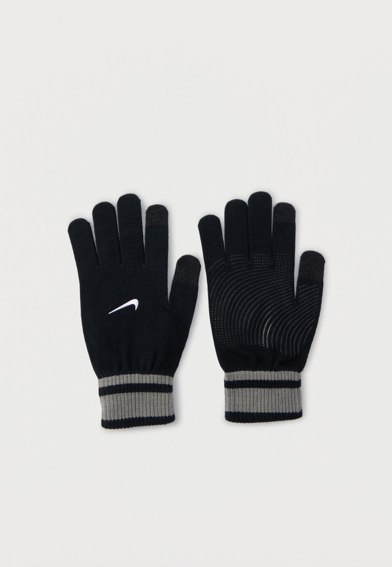 Fekete kötött kesztyű szürke mandzsettával, érintőképernyős ujjvégekkel, texturált tenyérfogással, és egy fehér Nike swoosh logóval az egyik kesztyű hátoldalán.