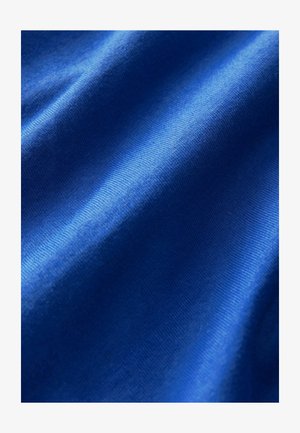 Sininen kangas, jossa on sileä pinta, hienovaraiset poimut ja tasainen kiilto, valuen pehmeinä laskoksina.