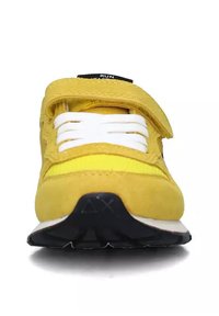 Scarpe da ginnastica gialle brillanti realizzate in suede e tessuto, con lacci bianchi, strap in Velcro e suola in gomma nera testurizzata.