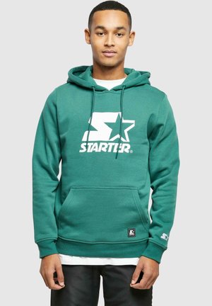 Green hooded sweatshirt with a large white "STARTER" logo and star design on the chest, featuring a front pocket and ribbed cuffs.