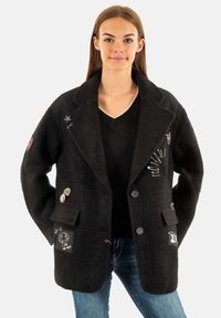 Cappotto in misto lana nero con rever a scialle, bottoni e toppe decorative. Presenta tasche frontali e una finitura testurizzata.