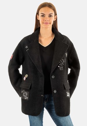 Manteau en laine noir mélangé avec un col cranté, des boutons et des patchs décoratifs. Dispose de poches avant et d'une finition texturée.