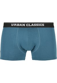 Teal Baumwollboxershorts mit einem schwarzen elastischen Bund, auf dem "URBAN CLASSICS" in weißen Buchstaben steht. Glatte Textur, enganliegendes Design.