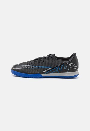 Černá a modrá indoorová kopačka Nike Air Zoom s tkaničkami, texturovanou podrážkou a bílým logem Swoosh na bílém pozadí.
