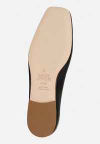 Schwarze Ledersohle mit einem glatten, hellbraunen Innenraum. Prägung mit Markenlogo und dem Detail "Made in Italy" sichtbar.