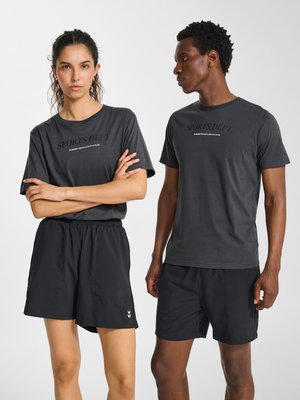 Kobieta i mężczyzna ubrani w pasujące ciemnoszare koszulki z napisem "SPORTS DEPT." oraz czarne sportowe spodenki na jednolitym białym tle.