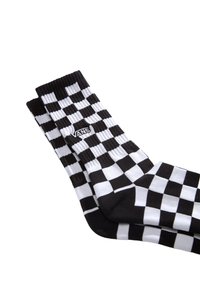 Calzini a scacchi bianco e nero realizzati in misto cotone, con una fascia a costine e il logo Vans al centro.
