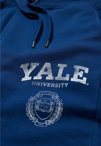 Blue fleece hoodie featuring white printed text “YALE UNIVERSITY” and a crest design with laurel accents and a book motif.