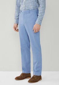 Pantaloni azzurri chiari realizzati in tessuto liscio, con una linea dritta, tasche frontali e una vita piatta con chiusura a singolo bottone.