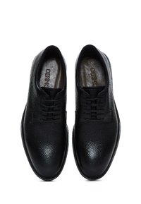 Zapatos de cuero negro con acabado texturizado, puntera redondeada y diseño de cordones. Presenta cordones oscuros y un interior suave.