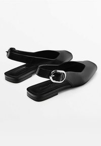 Schwarze Slingback-Schuhe mit quadratischer Zehenpartie, flacher Sohle und einem silbernen Schnallenakzent am Riemen; aus glattem synthetischem Material gefertigt.