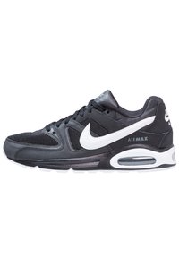 Nike Air Max sneakers hebben een zwarte mesh- en synthetische bovenkant, een witte accentlogo, een gevoerde kraag en een zichtbare luchtunit in de zool.