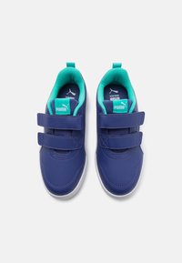 Chaussures synthétiques bleues avec une finition lisse, dotées de deux bandes Velcro, d'un intérieur teal et d'une semelle en caoutchouc blanc.