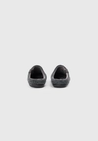 Pantofole in feltro grigio con un morbido interno, design a punta rotonda e una suola in gomma nera. Presentano cuciture minime e un anello sul tallone.