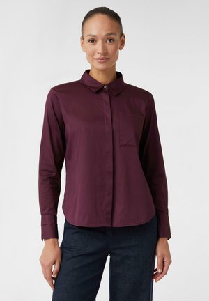 Bordeaux knopenhemd met kraag, lange mouwen, enkele borstzak en een gladde stof. Rondgaande zoom en omgeslagen mouwen.