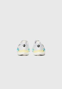 Sports shoes featuring a predominantly white mesh upper with grey accents, turquoise heel, and yellow sole. Branding on the heel.