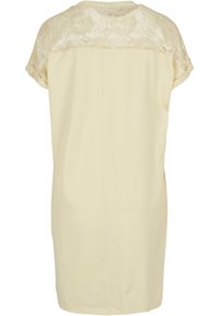 Short sleeve dress in pale yellow fabric with a lace yoke, featuring a straight cut and subtle seam detailing at the back.