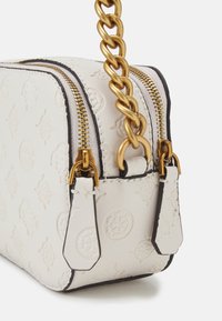 Sac en cuir blanc embossé avec une chaîne dorée, double zips et accents noirs. Présente des motifs complexes et une finition texturée.