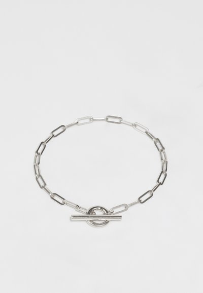 Bracelet en chaîne en argent avec des maillons allongés, un fermoir à bascule rond et un accent en barre droite pour la fermeture. Fini métallique lisse.