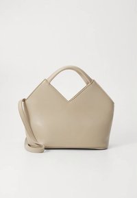 Beige faux leather handbag with a unique V-shaped top, dual handles, and a detachable shoulder strap. Smooth texture and structured shape.