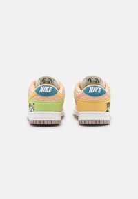 Nike sneakers i pastellfärger; har en design i orange, rosa, grön och gul med en blå logotyp och unika dekorativa detaljer.