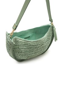 Bolso tejido verde con ribete de cuero liso. Cuenta con cierre de cremallera y una correa ajustable. El interior es de tela lisa verde a juego.