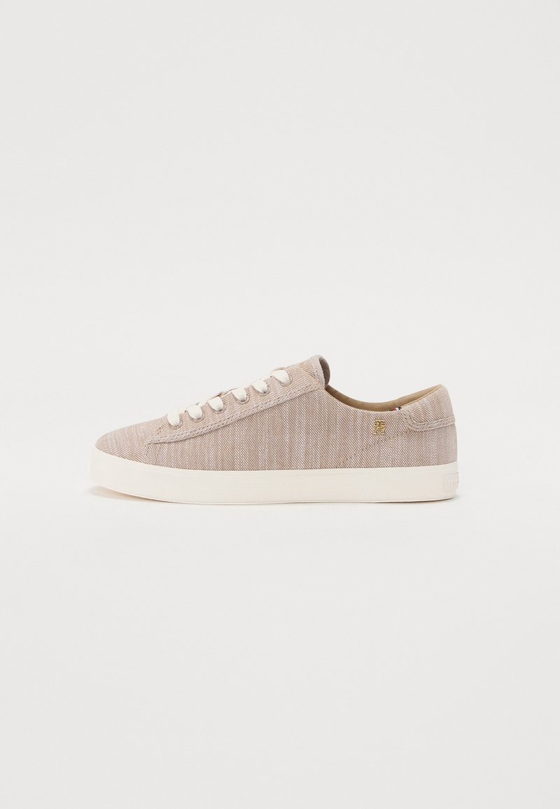 Baskets basses beige en toile avec lacets blancs et semelle épaisse en caoutchouc blanc, vues de côté extérieur sur fond blanc uni.