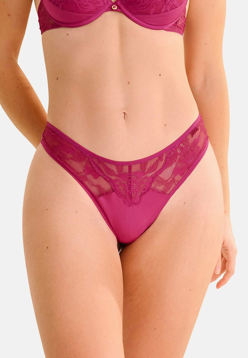 Paarse kanten lingerie met een bloemenpatroon, doorschijnende gaasaccenten en een lage taille. Soepele textuur met decoratieve stikseldetails.