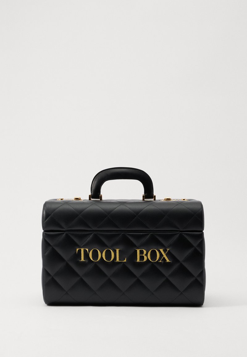 Czarna torba na narzędzia pikowana z złotym napisem "TOOL BOX", w usztywnionym kształcie, z górnym uchwytem i złotymi akcentami hardware.