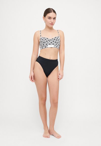 Black high-waisted bikini bottom paired with a cropped top featuring a monochrome graphic pattern. Thin straps and smooth texture.