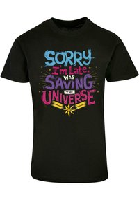 Camiseta negra con texto colorido: "Lo siento, llegué tarde. Estaba salvando el universo" con acentos de estrellas y estilos de fuente variados.