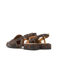 Braune und schwarze Sandalen mit Muster und einem klobigen Absatz, die ein offenes Design an den Zehen und verstellbare Riemen am Knöchel haben. Hergestellt aus strukturiertem Material.