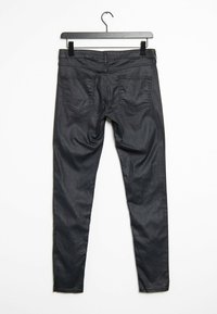 Černé skinny džíny vyrobené z hladkého, elastického materiálu. Obsahují dvě zadní kapsy se jemným vzorem šití. Visí na černém háčku.