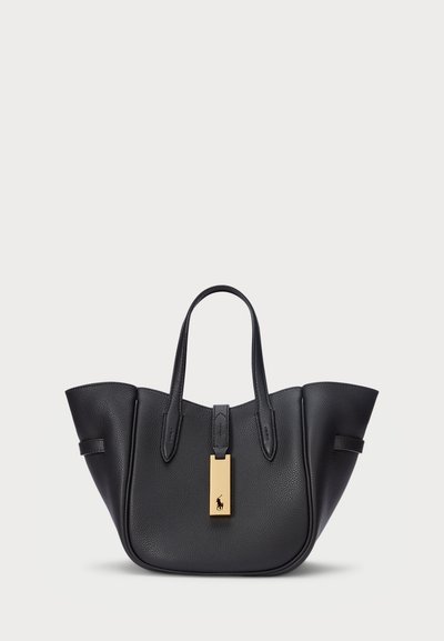 Borsa tote in pelle nera con texture liscia, ampia apertura, due manici corti e un'etichetta dorata con un dettaglio del logo. Crea una forma elegante.