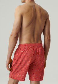 Czerwone kąpielówki z wzorzystym designem, na którym znajdują się małe ikony. Elastyczny pas z sznurkiem, boczne kieszenie i lekki materiał.